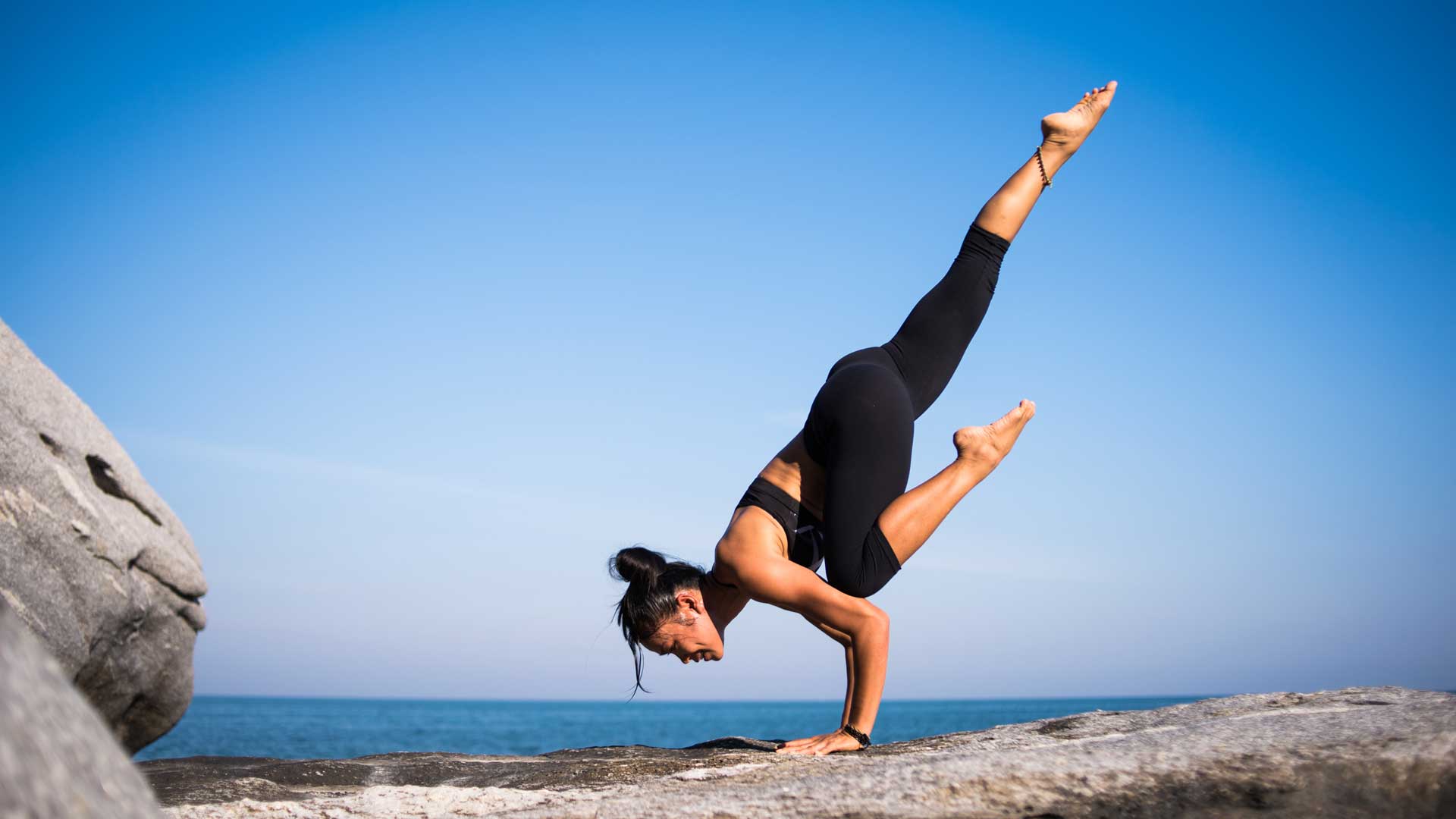 woman doing yoga at the sea