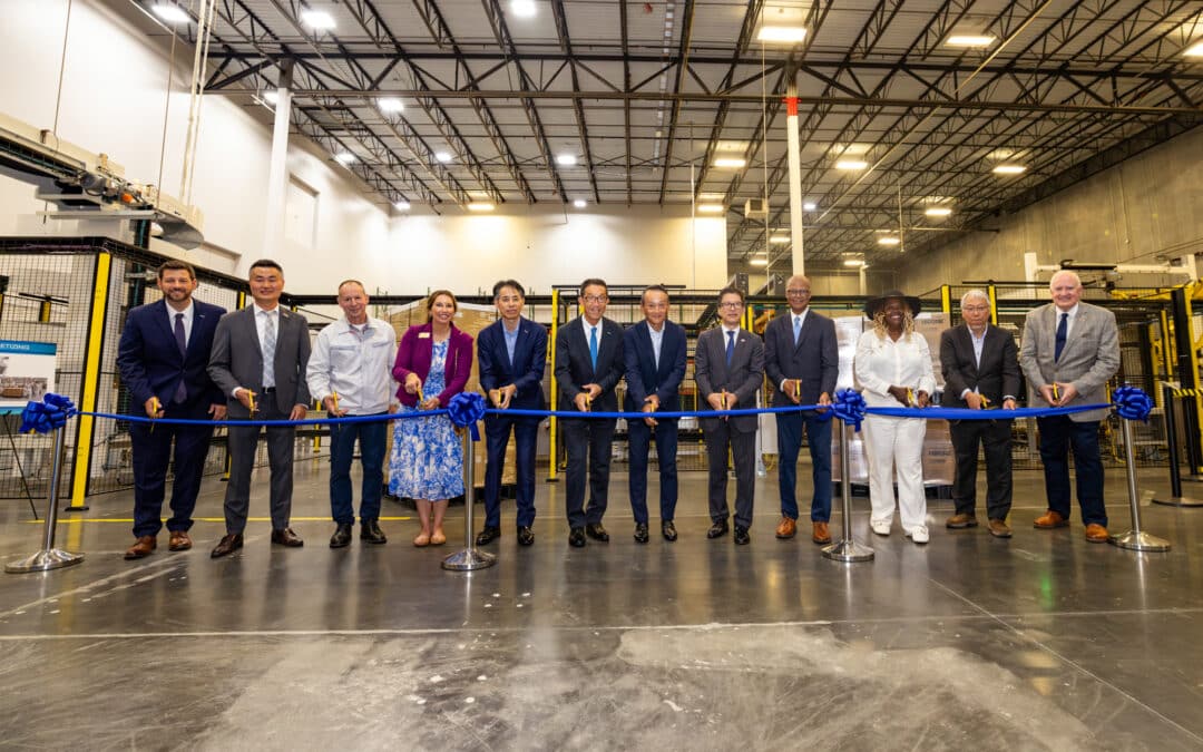 Attendees participate in a ribbon-cutting ceremony to celebrate the completion of the separator coating line / Teilnehmer feiern Eröffnung der Separator Beschichtungslinie